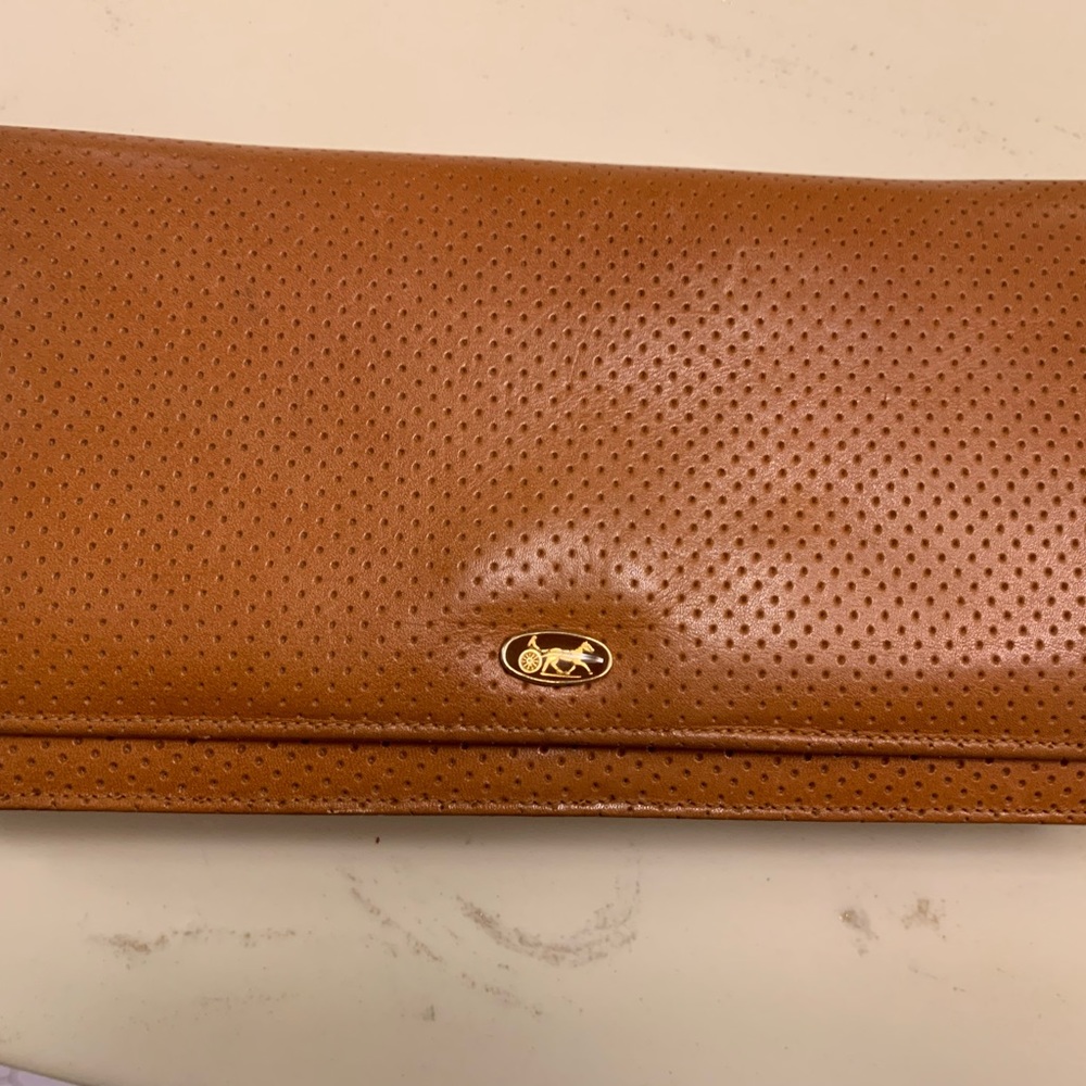 Golden tan clutch bag with chain strap. Chariot logo.